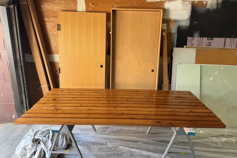 Freshly stained planks on sawhorses.